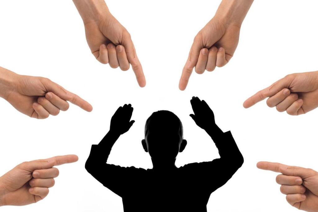 下降グラフを指差す手とショックを受けるビジネスマンのシルエット