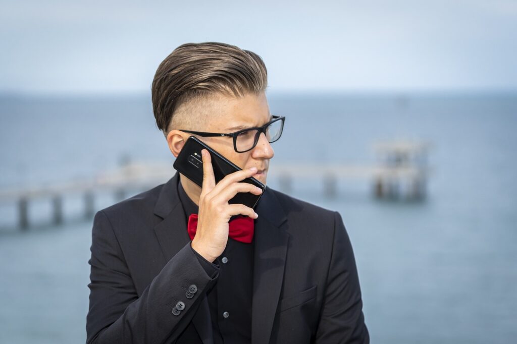 電話で予約を取ろうとする男性